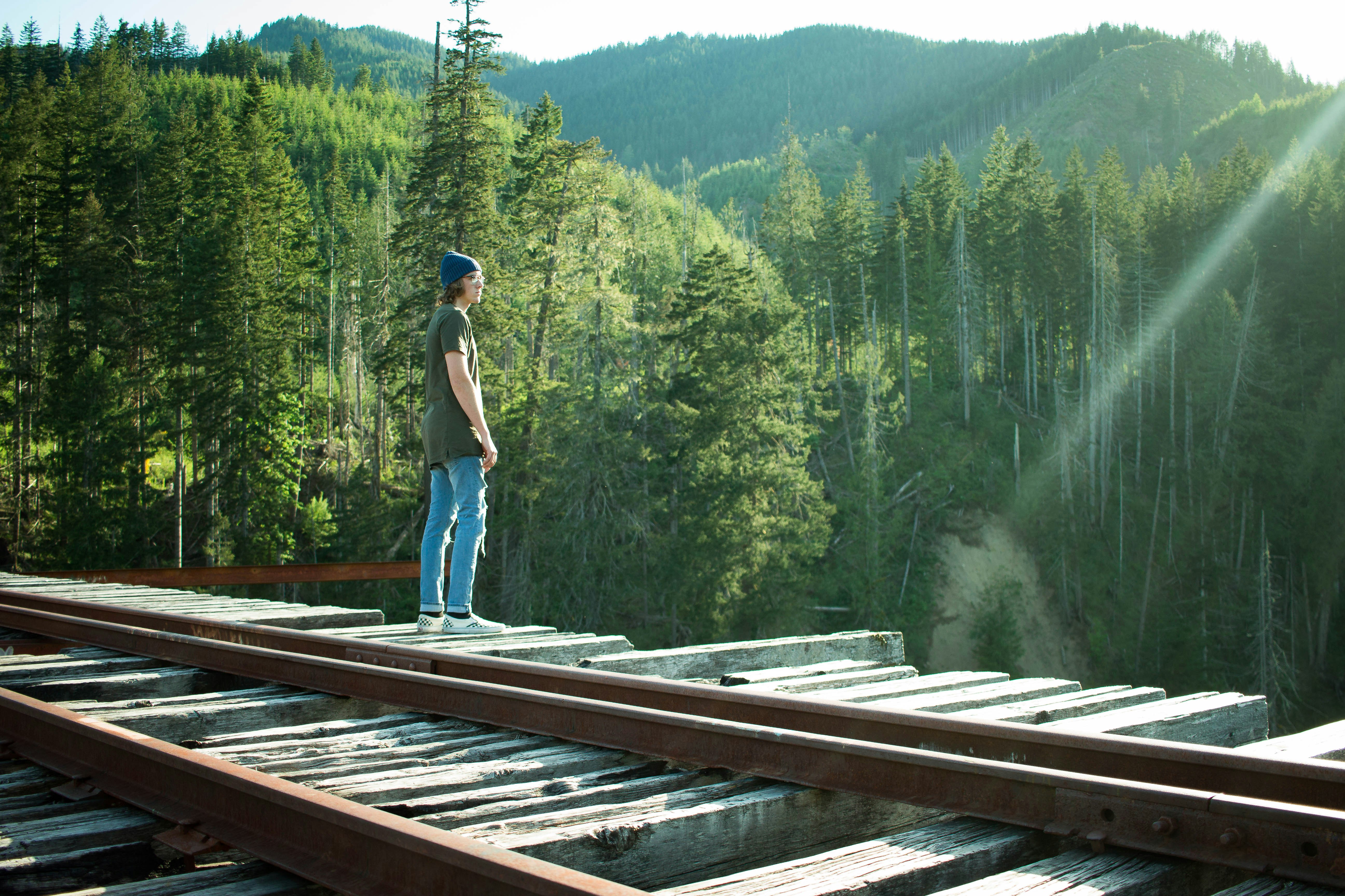 man standing on wooden bridge